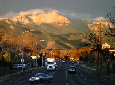 Middle of the Street in my Pajamas!
I was getting my three boys ready for school this morning, and I saw that it was an overcast day.  About 15 minutes later, I caught a glimpse out the kitchen window of Pikes Peak shining in the most beautiful colors!  I grabbed the camera and ran outside and took a couple of shots.  If it looks like I was in the middle of the street, I was.  ...in my pajamas, even.  I accidentally left the camera on 1600 ISO from the gecko shot yesterday, and I missed the peak colors, but it is still a decent shot.  It is nice to see this view every day, even with the power lines, street lamps, and other distractions!  (not to mention the traffic bearing down on me!)