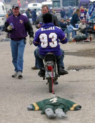 This guy is dragging a Packer Football fan in effigy behind his motorbike.