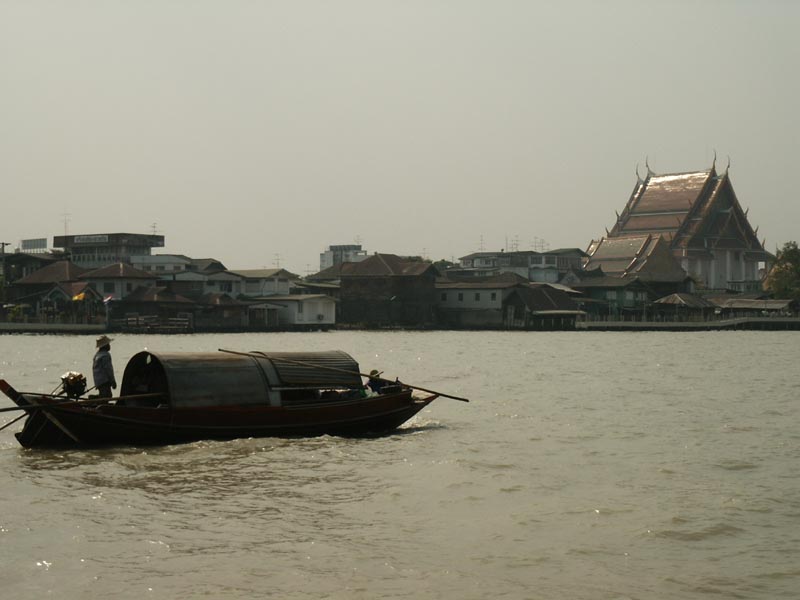 Traditional boat on the river in front of Wat Kalayanamit, Bangkok