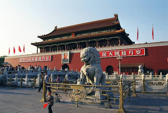 Small boy with flag in front of Chinese Lion, Tianamen Square