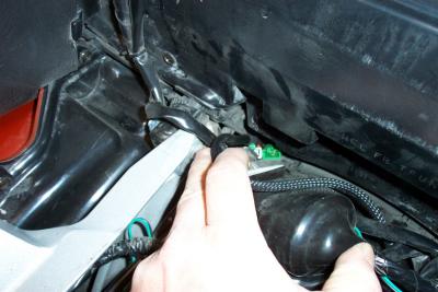 There is a hole on the right rear side of the trunk you can fish the harness through