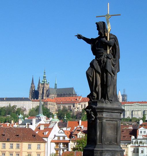 A Charles Bridge Statue points the way to Prague Castle