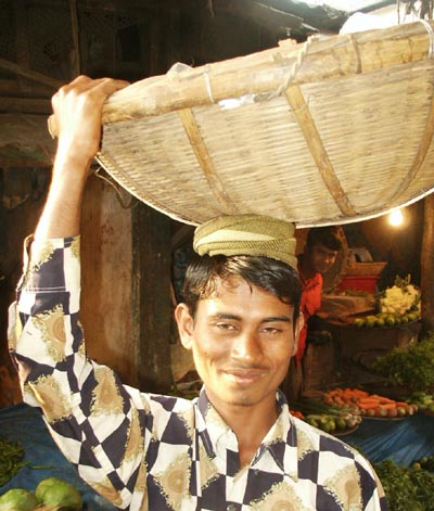 Young man carrying basket on his head, Bangladesh