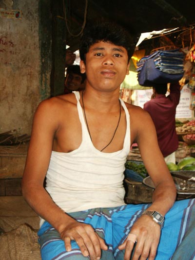 Young man in t-shirt, produce market, Dhaka