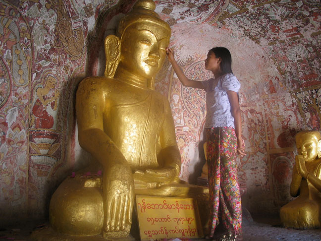 Applying gold leaf to the Buddha.