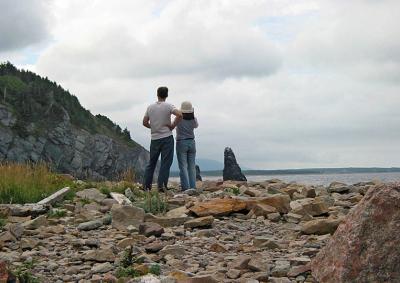 Admiring coastal scenery from rock and boulder strewn shore.
