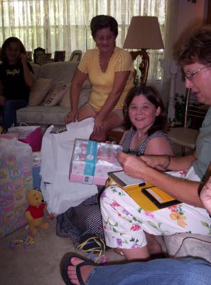 Jennifer opening presents.  This one happened to be from the baby's father and was a baby bank that he'd taped a penny, nickel, dime & quarter to the outside of, all 2004 models, representing their baby's birth year.