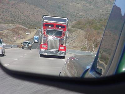 red big rig truckerin the rearview mirror