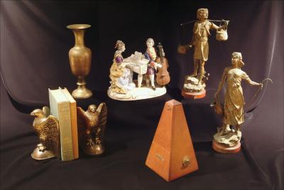 12. bookends, porcelain figurines, base metal peasant statues, an Indian brass vase, & a metronome