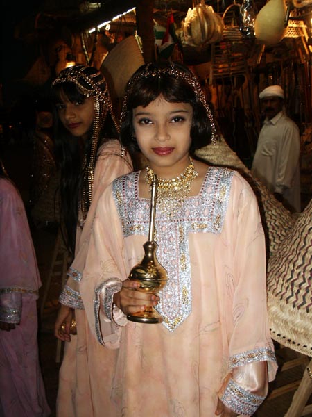 Young Emirati girl welcoming guests with rosewater