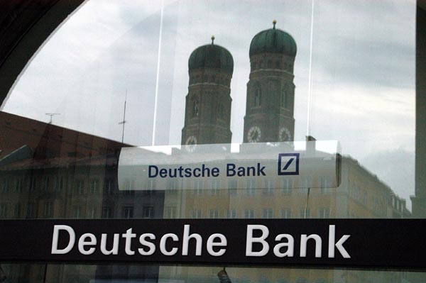 Die Türme der Frauenkirche spiegeln sich im Fenster der Deutschen Bank