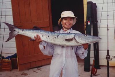 My daughter had a big smile on her face, but she was in pain from holding up her 33-pound barracuda