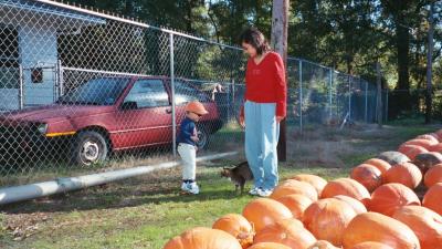 Ben and Mama play with the cat in the pumpkin patch