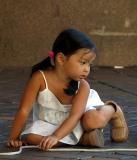 Little girl with rope deep in thought