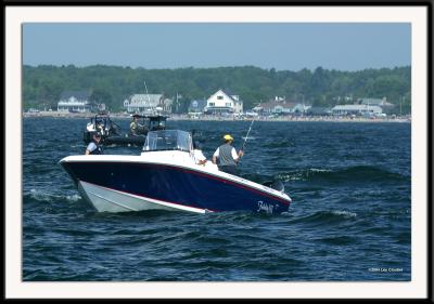 President Bush (41) fishing off the coast of Maine. The Secret Service Zodiac raft can be seen in the background. Photo taken from several hundred yards away using a 400 mm lens in very choppy seas. President Bush is partially hidden in the blue baseball cap.