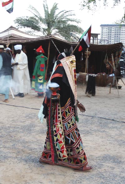 Sudanese woman carrying a steaming cup
