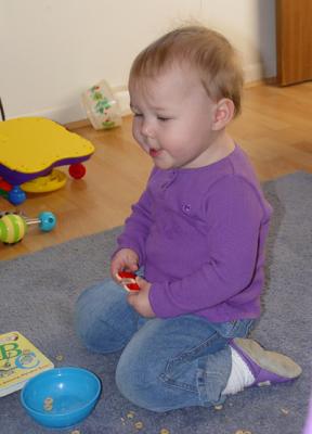 Reagan checking out the mess of cherrios she just made