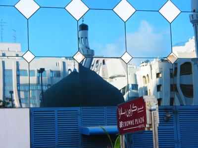 Sign outside of hotel and reflection of the mosque