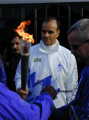 NY Yankee manager Joe Torre and the lit Olympic Torch