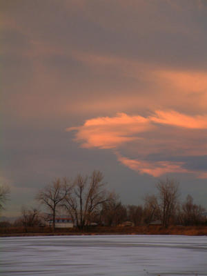 Sunset-lit cloud over a frozen lake