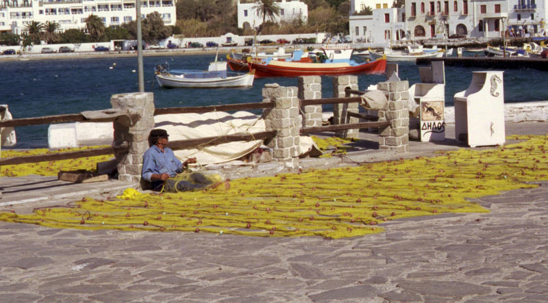 A fisherman mends nets on Mykonos