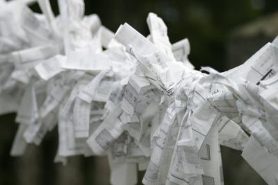 Omikuji are fortune telling paper slips found at many shrines and temples. Randomly drawn, they contain predictions ranging from daikichi (great good luck) to daikyo (great bad luck). By tying the piece of paper around a tree's branch, good fortune will come true or bad fortune can be averted. 

(This wording is from this, very informative, site:  http://www.japan-guide.com/e/e2059.html)