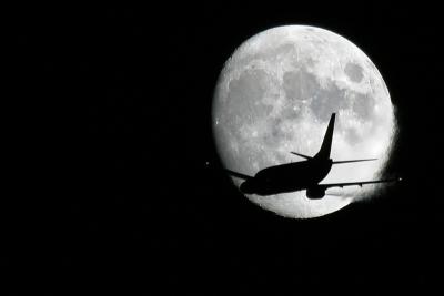 Aer Lingus 737 flies in front of the moon.