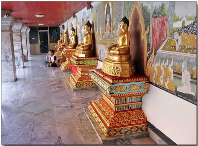 Buddha idols facing the golden chedi
