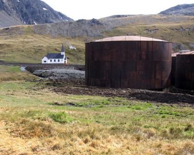 Adandoned fuel oil tanks and the restored church.