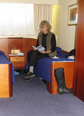 Dee poses in our cabin with Todd's Birds & Mammals of the Antarctic, Subantarctic & Falkland Islands, our basic reference.