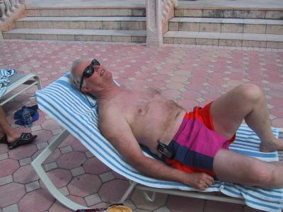 Jim H. sunning beside the pool at hotel