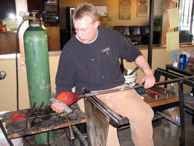 Spencer molds the piping hot glass with wet newpaper for protection, the next best thing to shaping with the hand