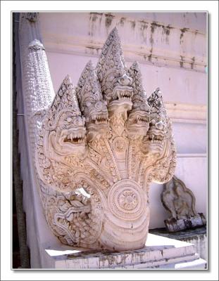 Naka at the base of a pagoda, Petchaburi