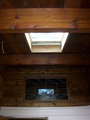 To let more natural light in, we installed a Velux skylight. 
The stained glass transom window was a great find at a recycled building supplies store.