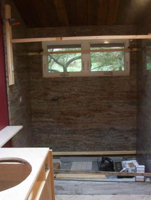 Shower wall installation begins! Amber Fantasy granite slab walls.