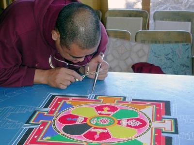 A young monk works on the beginning of the Mandala. It will take them 75 hours to complete.