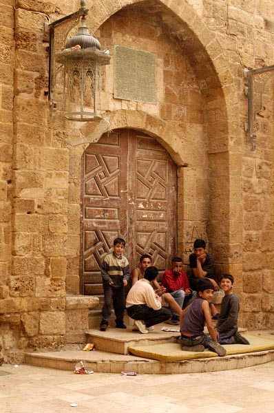 Local kids hanging out in front of an ornate door in medieval Sidon