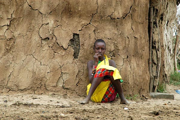 Woman leaning against a hut