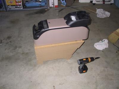 The enclosure is a stand for a center console. Installed, the top of the console is even with the tops of the front armrests.
