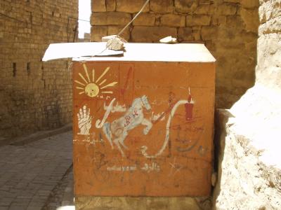 This is a political sign: the horse is the ruling party; the sun is the opposition. These symbols are everywhere