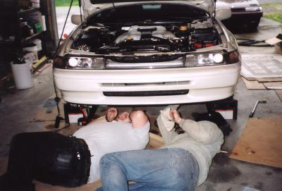 Headless people working on a car