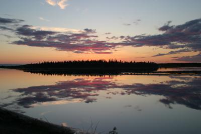 Sunrise and clouds reflected on river