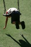 Boy on swing with his shadow