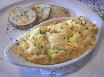 Baked eggs with ham, onions, tri-colour peppers & cheese; roasted, herbed potatoes