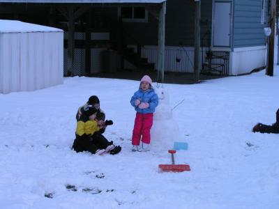 Kyle, Sarah, and Emily finishing up the snowman