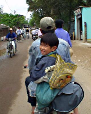 Smiling Kid on Moto in Hue