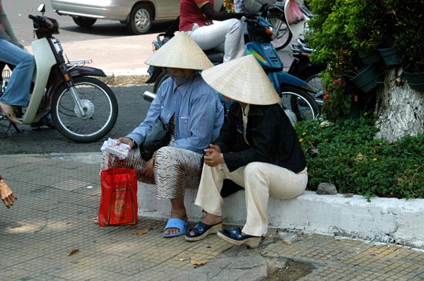 Many people still wear the traditional Southeast Asian cone shaped hats