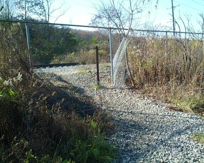 Chain Link fence breached to cross the RR tracks