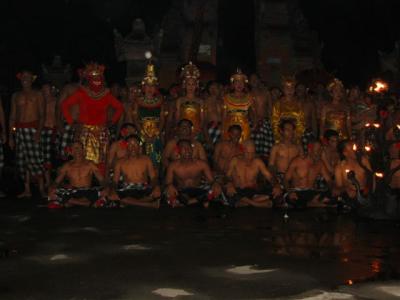 Probably the best known of the many Blinese dances, the Kecak is unusual in tht it does not have a gamelan accompaniment.  Instead the background is provided by a chanting 'choir' of men who provide the 'chak-a-chak-a-chak' noise.  Originally, this chanting group was known as the Kecak and was part of a Sanghyang trance dance.  Then, in the 1930s, the modern Kecak developed in Bona near Gianyar in East Bali, where the dance is still held regularly.
  The Kecak tells a tale from the Ramayana, one of the great Hindu holy books, about Prince Rama and his Princess Sita.  With Rama's brother, Laksamana, they have been exiled from the kingdom of Ayodya and are wandering in the forest.  The evil Rawana, King of Lanka, lures Rama away with a golden deer (which is really Lanka's equally evil prime minister, who has magically changed himself into a deer).  When Rama fails to return, Sita persuades Laksamana to search for him.  When the princess is alone, Rawana pounces and carries her off to his hideaway.