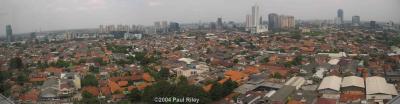 Jakarta skyline - tall office blocks and red clay tiled roofs